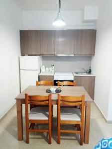 une cuisine avec une table en bois et quatre chaises dans l'établissement Zea Waves apartments, à Kastrí