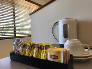 una mesa con una caja de cereales y una cafetera en Bay Village Tropical Retreat & Apartments, en Cairns