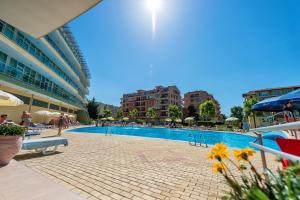 a swimming pool in a resort with people and umbrellas at Ivana Palace Hotel - Free Parking in Sunny Beach