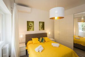 a bedroom with a yellow bed with towels on it at Lovely New Apartament, Viale Trastevere in Rome