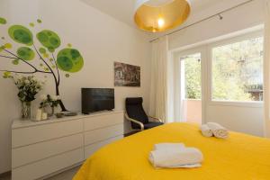 a bedroom with a yellow bed and a tv at Lovely New Apartament, Viale Trastevere in Rome