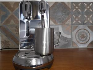 a silver coffee maker sitting on top of a table at El Puerto Bed and Breakfast in Hoorn