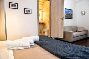 a bedroom with a bed and a living room with a couch at Corso 151 in Olbia