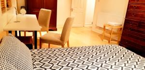 um quarto com uma cama, uma mesa e cadeiras em Covent Garden Penthouse em Londres