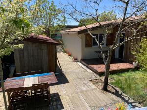 uma casa com um deque, uma mesa e cadeiras em Lachanau Paradis em Hourtin