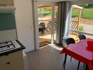 a kitchen with a table and a view of a deck at Camping Manaysse in Moustiers-Sainte-Marie +30 photos