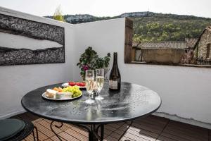 a table with a plate of food and wine glasses at La Résidence Chambre d'Hotes in Saint-Antonin