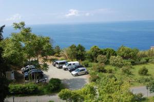 博納索拉的住宿－拉弗朗切西卡度假酒店，一群停在靠近海洋的停车场的汽车