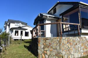 una casa con una pared de piedra delante de ella en Cabañas Vista Tranquila Chiloé, en Castro