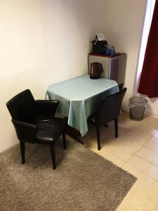 a table and two chairs and a table and a chair at Appartement Hotel Marien-Hof in Vienna