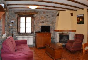 Una sala de estar con un sofá y una chimenea. en Casas Rurales Las Corradas, en Éndriga