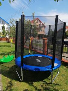 a playground with a blue and black trampoline at Orka Wakacje in Dźwirzyno