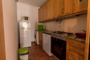 a kitchen with a stove and a white refrigerator at APARTAMENTO TELHEIRO in Vila Nova de Milfontes