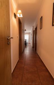a hallway with a tile floor and a door at APARTAMENTO TELHEIRO in Vila Nova de Milfontes +1 photo