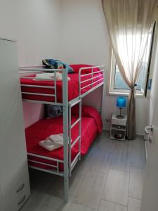 Un dormitorio con dos literas y una ventana. en Villa Andrea, en Catania