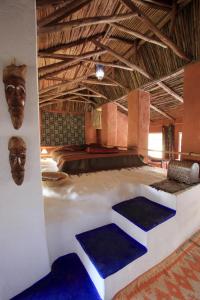 Cette chambre comprend un grand lit avec une tête sur le mur. dans l'établissement Maison d'hotes Berbari, à Assilah