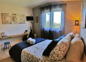 een slaapkamer met een bed en een raam bij La Villa Esterel & SPA in Village-Neuf