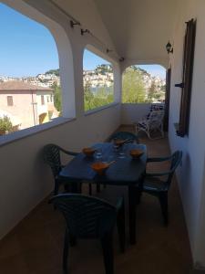 comedor con mesa, sillas y 2 ventanas en Casa Ermanno en Posada