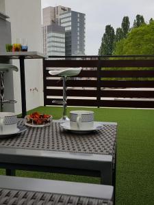 une table avec deux tasses et des assiettes sur un balcon dans l'établissement Rooftop studio with XL balcony in center of Zagreb, à Zagreb