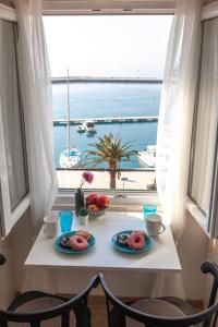 stół z dwoma talerzami jedzenia przed oknem w obiekcie Seafront Center Apartment Fyaka w Makarskiej