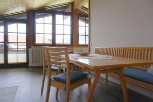 een eetkamer met een houten tafel en stoelen bij Ferienwohnung am Frohmarkt in Oberstdorf