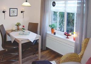 a dining room with a table and a window at Ferienwohnung Nowara in Krummhörn