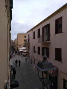 a street scene with people walking down the street at Piazza Ginnasio Affittacamere in Alghero