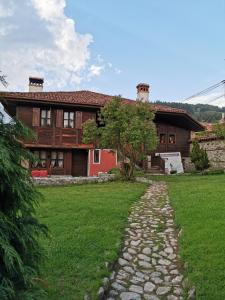 una casa con un camino de piedra delante de ella en Hadji Neikovi Guest Houses, en Koprivshtitsa