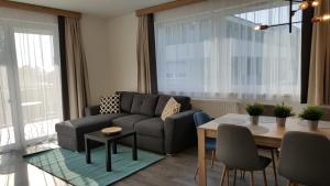 a living room with a couch and a table at Lelle Resort CB34 in Balatonlelle