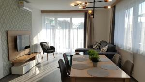 a living room with a table and a couch and a tv at Lelle Resort CB34 in Balatonlelle