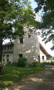 an old stone building in the middle of a yard at Le Moulin d' Erée, gîte Insolite de charme in Soudan