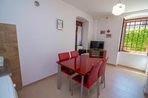 comedor con mesa roja y sillas rojas en Andjelka B4-Blue en Mali Lošinj