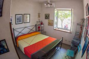 a bedroom with a colorful bed and a window at casa delle palme in Ustica +41 photos