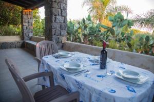 a table with a bottle of wine sitting on a patio at casa delle palme in Ustica
