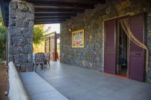 a patio with a stone wall and a purple door at casa delle palme in Ustica