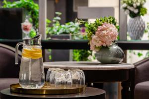 einen Tisch mit zwei Gläsern und eine Vase mit Blumen in der Unterkunft Hotel Elysée Etoile in Paris