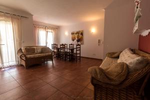a living room with couches and a table and chairs at APARTAMENTO TELHEIRO in Vila Nova de Milfontes