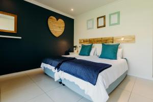 um quarto com uma cama grande e almofadas azuis em Whale Rock Gardens 15 - partial inverter em Plettenberg Bay