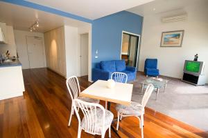 a living room with a table and chairs and a couch at Anchorage Motel & Villas Lorne in Lorne