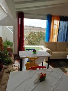 ein Wohnzimmer mit einem Tisch, einem Sofa und einem Fenster in der Unterkunft Borgo Manfria in Gela