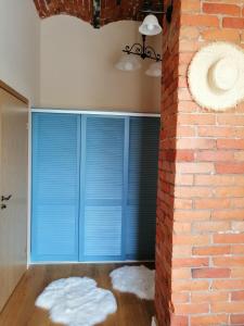 um quarto com persianas azuis e uma parede de tijolos em Stylish apartment with sauna em Kuressaare
