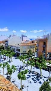 a park with trees and buildings in a city at Hostal Can Joanet in Cambrils