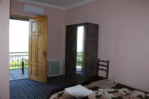 a bedroom with a bed and a door to a balcony at Guest House Shota in Sighnaghi