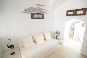 Sala de estar blanca con sofá blanco en Menias Cave House en Oia