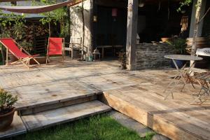 a wooden deck with chairs and a table on it at L'Eaubergerine in Herbeumont