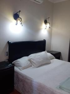 - une chambre avec un lit blanc et deux lumières sur le mur dans l'établissement 321or322 the finest Porto Marina Chalets Tower 3, à El Alamein