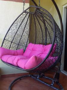 a hanging basket bed with pink pillows in it at 321or322 the finest Porto Marina Chalets Tower 3 in El Alamein