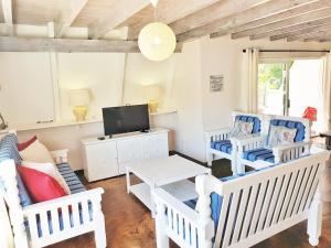 a living room with white chairs and a tv at Beach you to it - Sedgefield in Sedgefield