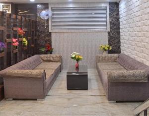 two brown couches in a room with flowers on it at Hotel Royal Suites in Ajmer