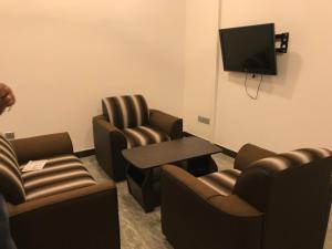 a waiting room with chairs and a tv and a table at Duvi's Shelter Bungalow in Colombo